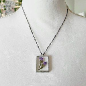 Purple floral botanical flower resin necklace in dark silver bezel